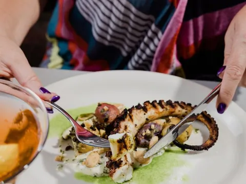Grilled octopus plated with sauce at Grace