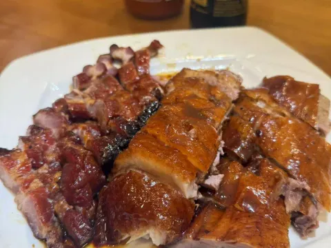 Platter of Cantonese roast duck and barbecued char siu pork at Ting Wong Restaurant in Philadelphia Chinatown, with chili and soy sauce bottles on the table
