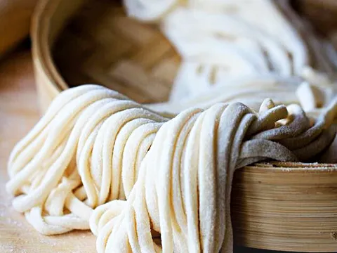 Hand-pulled noodles coiled in a bamboo steamer at Shang Artisan Noodle