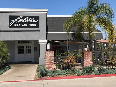 Lolita's Mexican Food storefront with black sign and gated brick patio at the Kearny Mesa location in San Diego