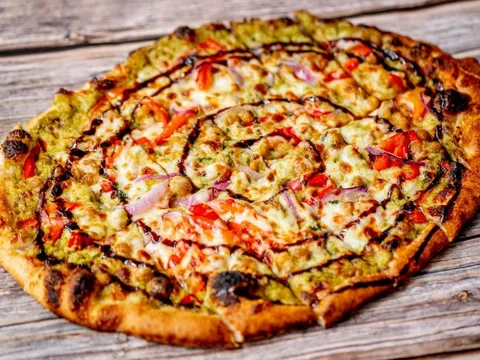 Wood-fired flatbread pizza with tomato, onion and herbs at American Flatbread Burlington Hearth