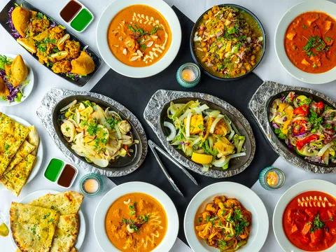 Overhead spread of curries, tandoori dishes and breads at Tandoori Flame