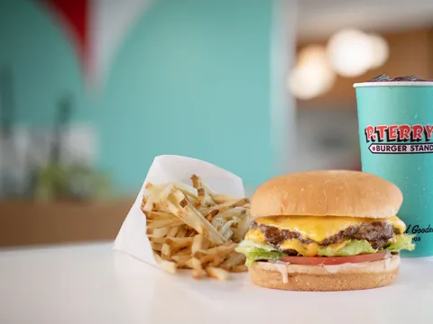 P. Terry's double cheeseburger, fresh-cut fries, and branded soft-drink cup on a restaurant table