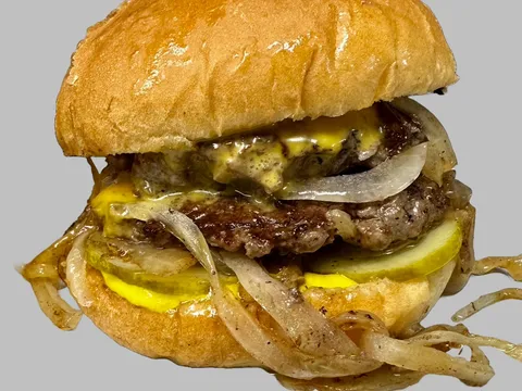 Motz's Burgers cheeseburger on a toasted bun with caramelized onions and pickles in Detroit