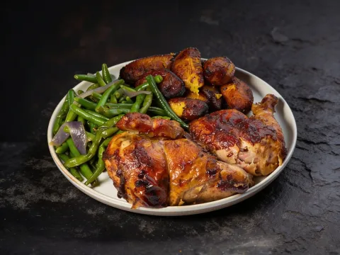 Charcoal rotisserie chicken meal with sauteed green beans and fried sweet plantains at Chicken Rico in Baltimore