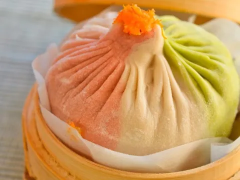 Colorful multi-flavored xiao long bao soup dumpling in a bamboo steamer at Shanghai You Garden