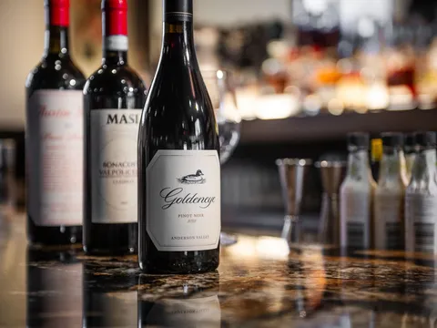 Bottles of red wine lined up on the bar at Andino's Restaurant