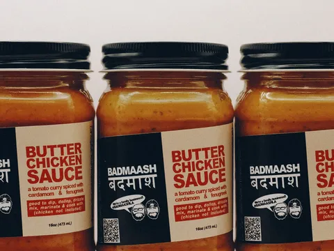 Three jars of Badmaash butter chicken sauce arranged on a white background