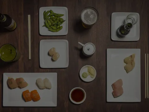 An overhead spread of Sugarfish nigiri, sashimi, edamame, beer and tea from the Trust Me menu at Sugarfish by Sushi Nozawa.