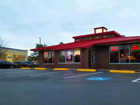 Red-roofed exterior of Portland House of Pizza at dusk, seen from the parking lot