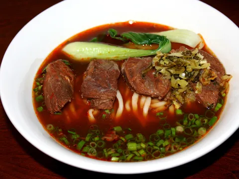 Bowl of braised beef noodle soup with bok choy, pickled mustard greens and scallions at Wu Wei Din Chinese Cuisine in Plano