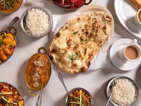 Curries, rice, naan and chai spread across a table at Siri Indian Cuisine
