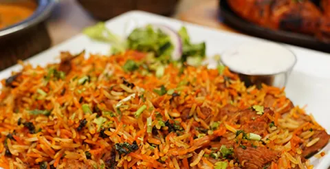 Platter of biryani with curry and tandoori chicken at Curry Corner