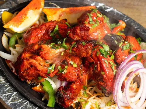 Sizzling platter of tandoori chicken with onions, peppers and lemon at Anjappar Chettinad