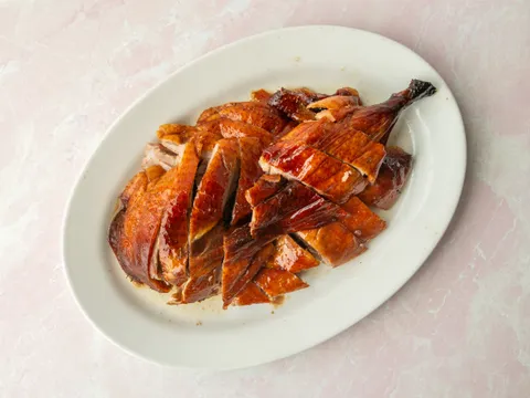 A whole Cantonese roast duck, chopped and arranged on a white oval platter at Sam Woo BBQ