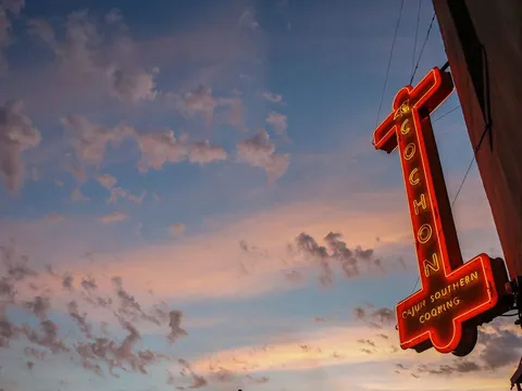 Illuminated Cochon restaurant sign against the evening sky in New Orleans