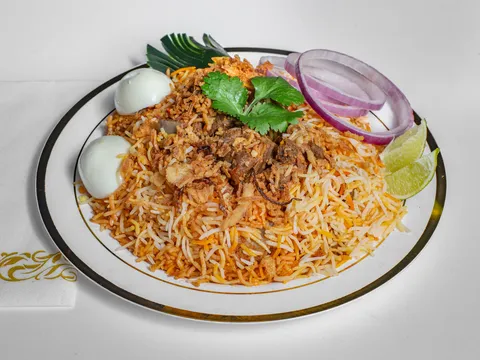 Plate of Hyderabadi mutton (goat) dum biryani with boiled egg, onion, and lime at Pastry Corner Cafe & Lounge