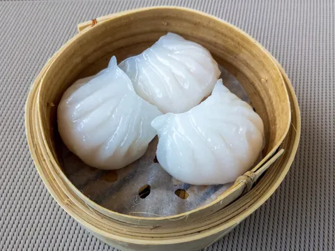 Steamed shrimp har gow dumplings in a bamboo steamer at Furama