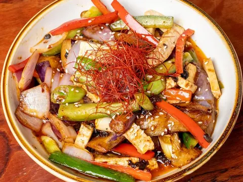 Wok-fried tofu and vegetables with peppers and chili threads in a bowl at Palette Tea House
