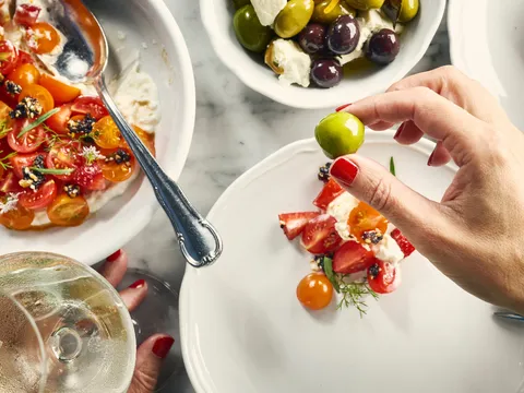 A colorful shared dish being finished with lime at Bavel