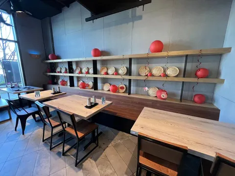 Empty dining room with red lanterns and shelved crockery at Dough Zone