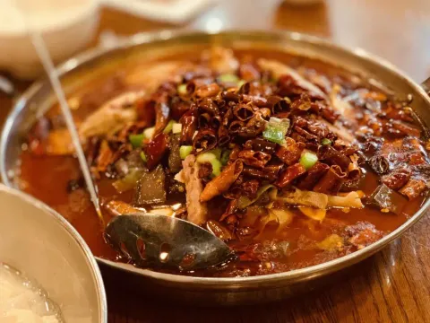 Sichuan boiled dish topped with dried red chilies and scallions in chili oil at Chengdu Taste Las Vegas