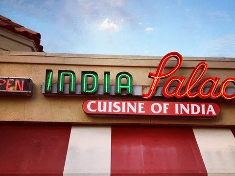Storefront sign of India Palace, Cuisine of India, in Tulsa with a neon 'Open' sign and red-and-white awning
