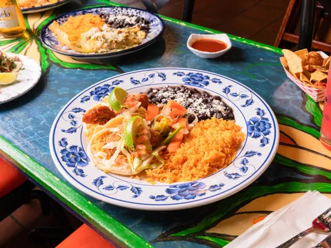 A fish taco plate with Mexican rice and black beans on a hand-painted Talavera table at El Metate Restaurant in San Francisco