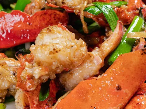 Wok-fried lobster with ginger and scallions plated on a white dish, a signature Cantonese seafood dish at Peach Farm in Boston Chinatown