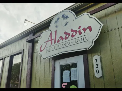 Storefront sign for Aladdin Mediterranean Grill beside the building number 730