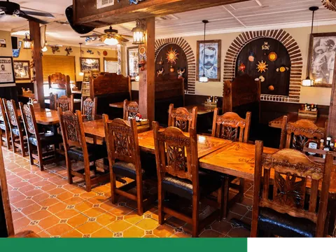 Carved wooden tables and chairs in the dining room at Chabely's Mexican Grill