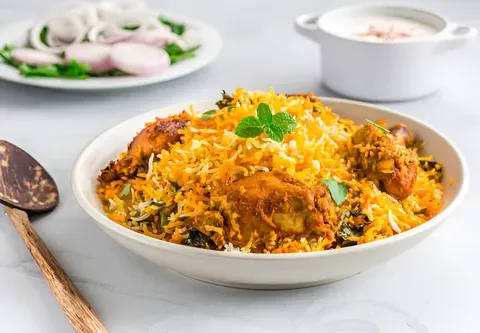 Namaste Flavours special chicken biryani served with raita, sliced onions and mint