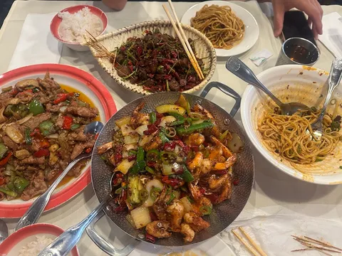 Table spread of Sichuan dishes and noodles at Chengdu Taste