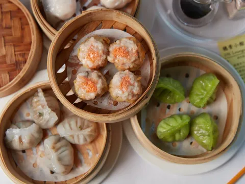 Assorted dim sum in bamboo steamers — siu mai, dumplings and spinach dumplings — at HK Lounge Bistro