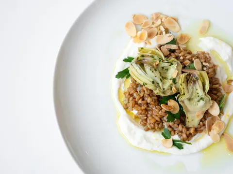 Nordic farro dish with artichokes, whipped cheese and toasted almonds on a white plate at FIKA Café, American Swedish Institute