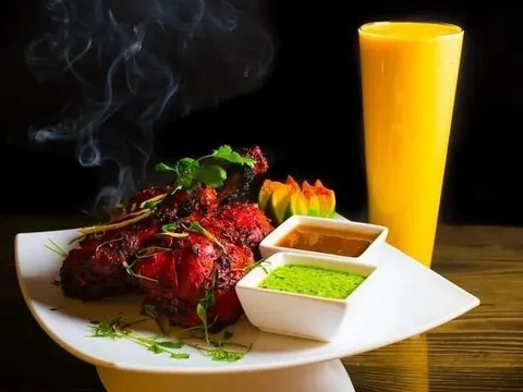 Tandoori chicken garnished with cilantro, served with mint and tamarind chutneys and a mango lassi at Pakeezah in Bozeman